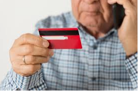 Elderly Person holding a Credit Card and on the Phone