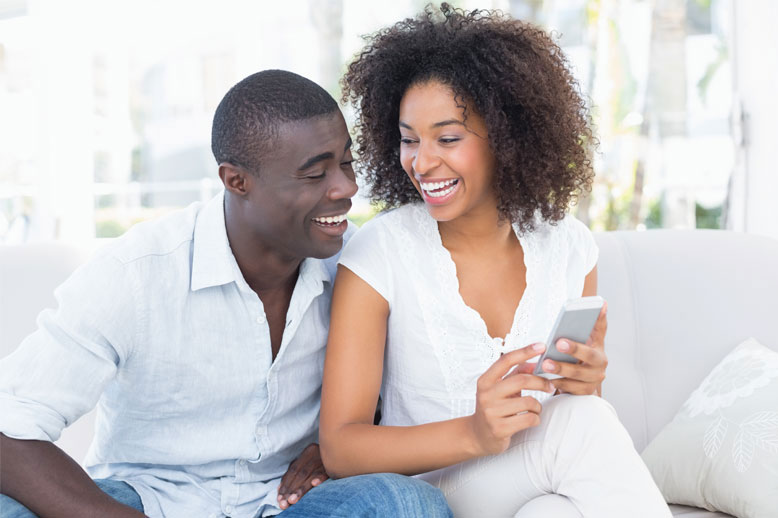 happy-couple-looking-at-phone-in-page
