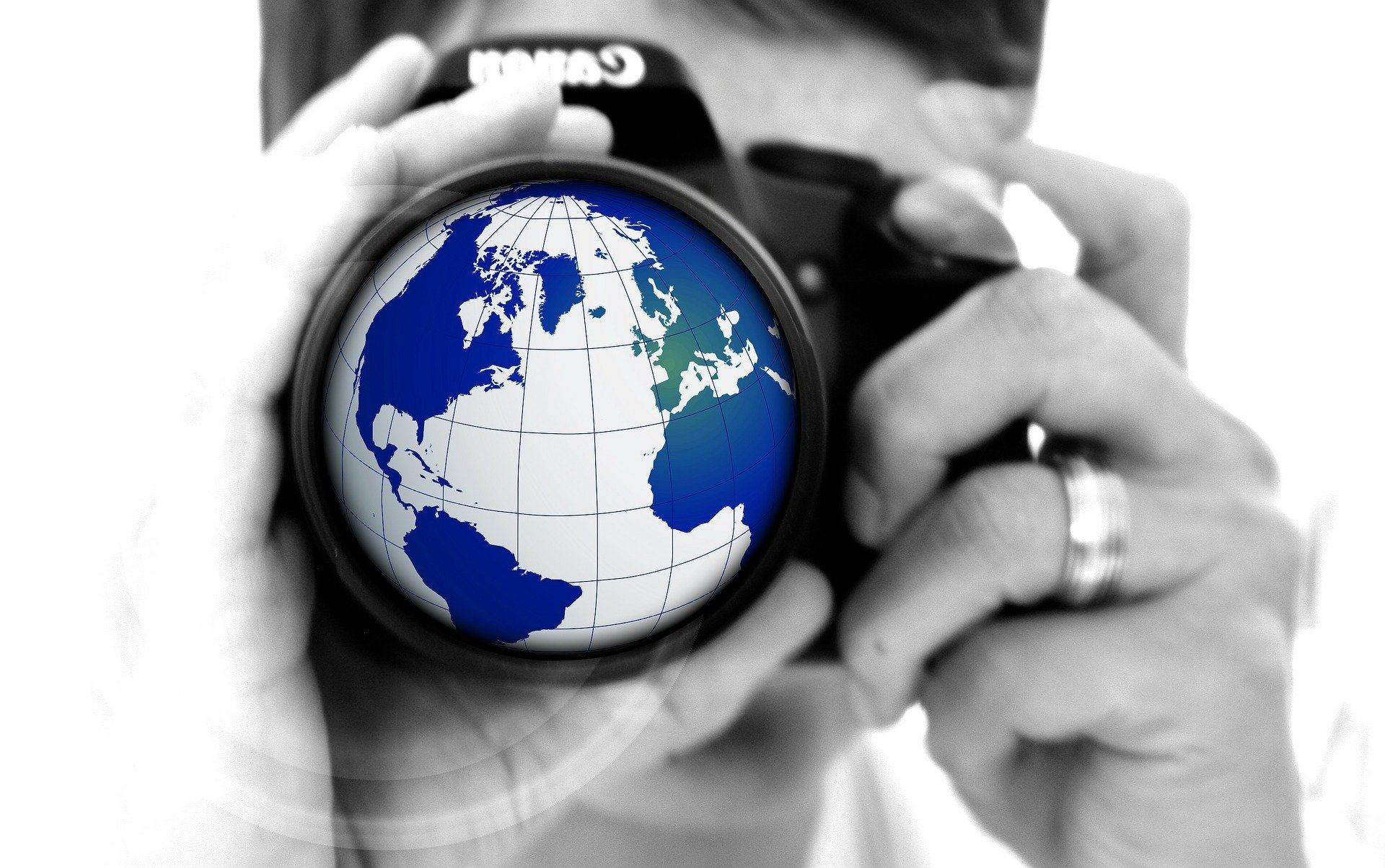woman looking into a camera with a picture of a globe within the lens frame.