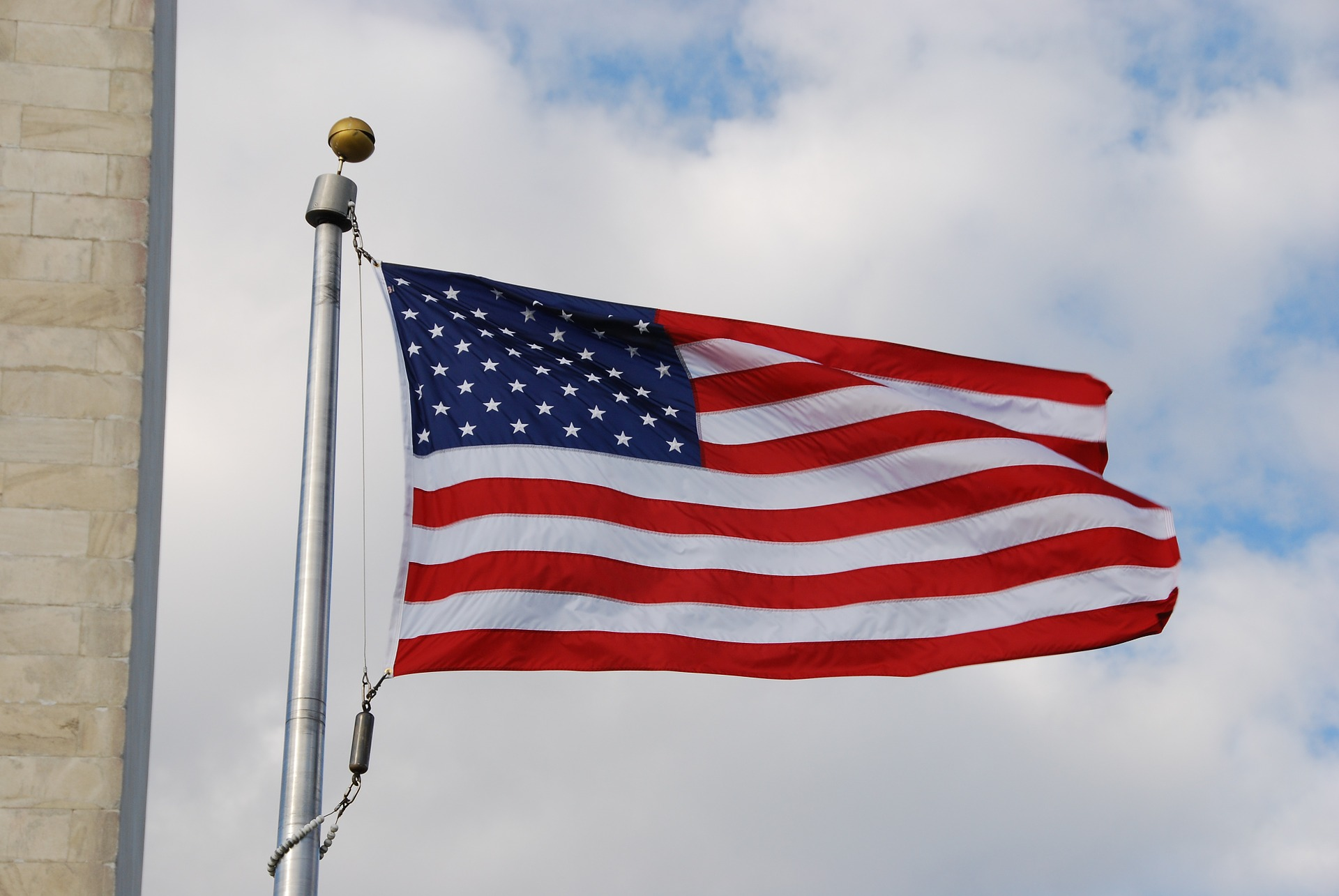 Close-up view of United States of America Flag flying on a flagpole.