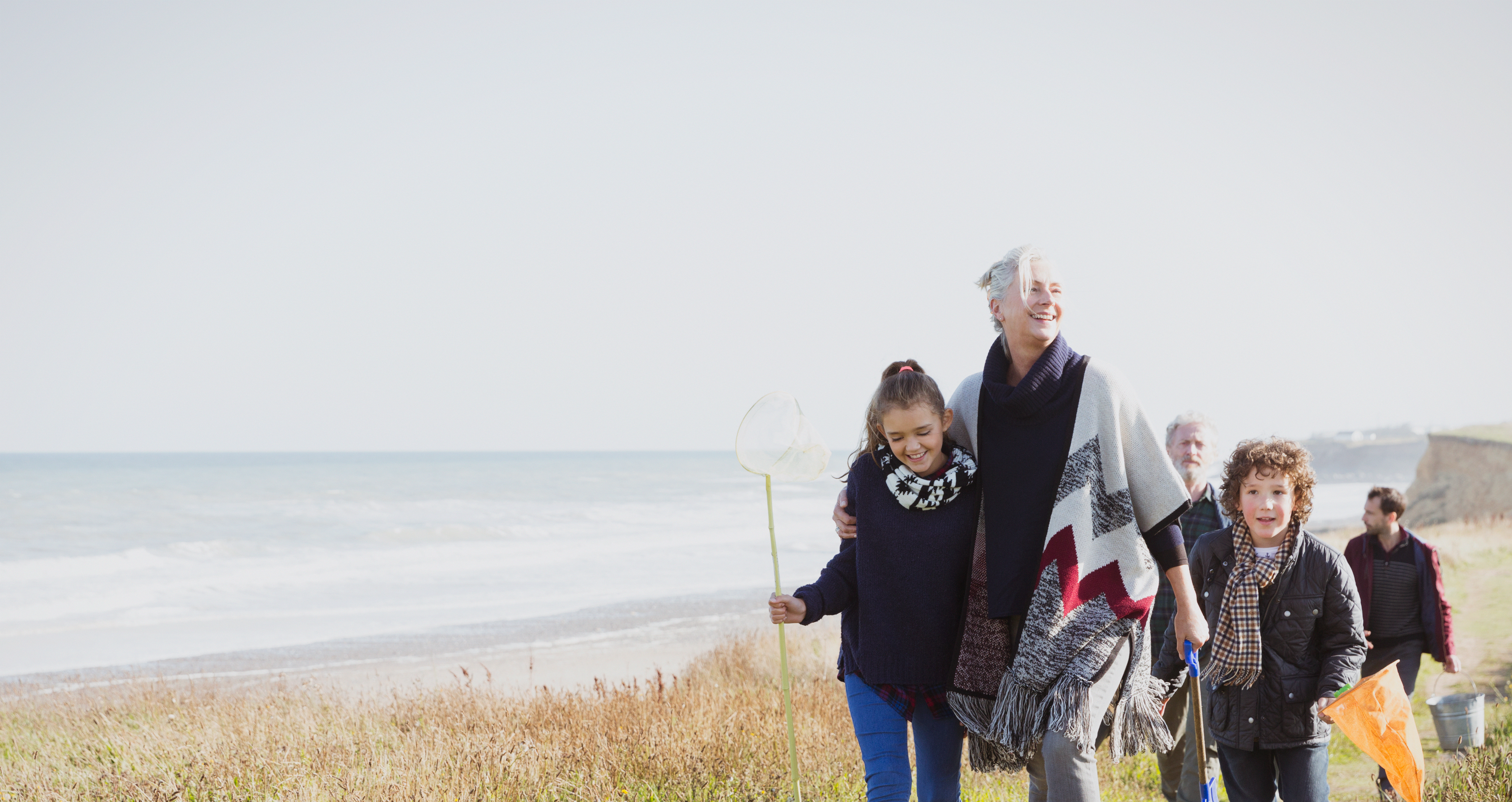 Grandmother with kids walking along a shore line