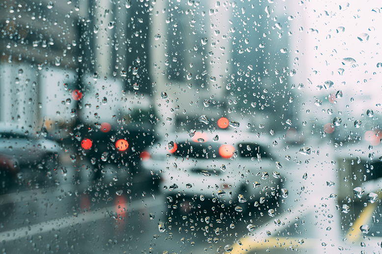 Car in traffic with rain droplets on the windshield