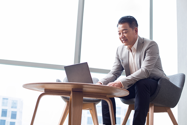 Man sitting at a desk working on a laptop