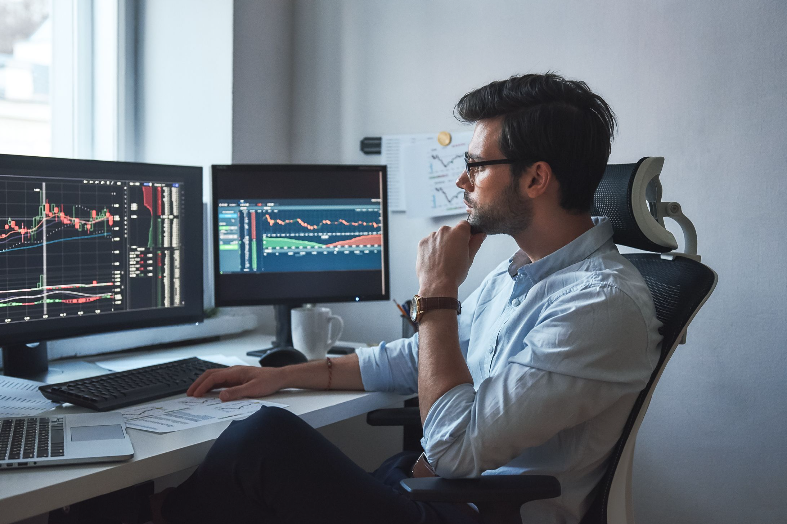 trader looking at market charts on computers