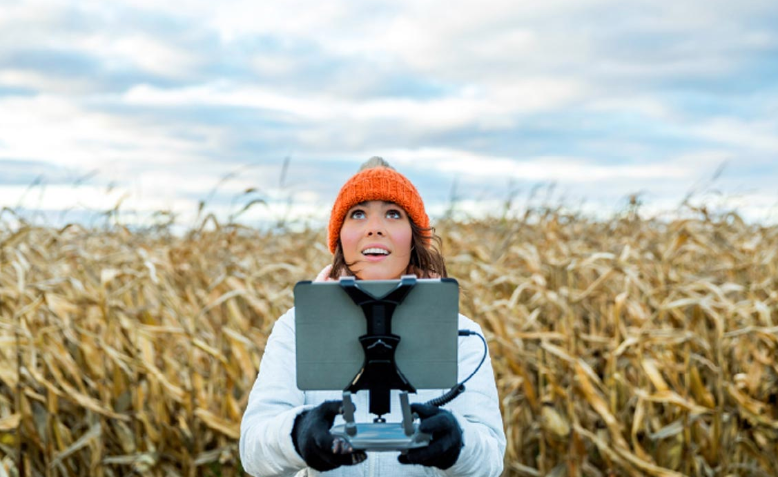 women in a farm field on computer in page