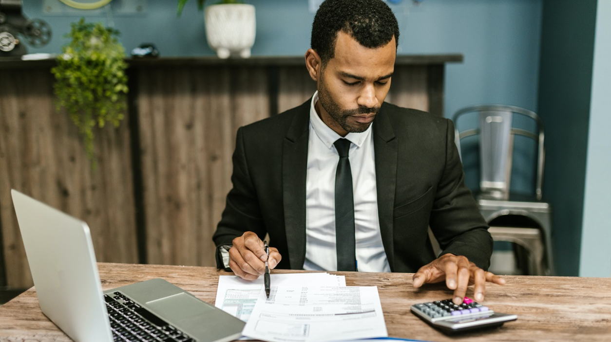 Business man working on his laptop and calculator