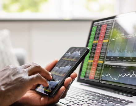 Graphs shown on a smart phone screen and a laptop computer.