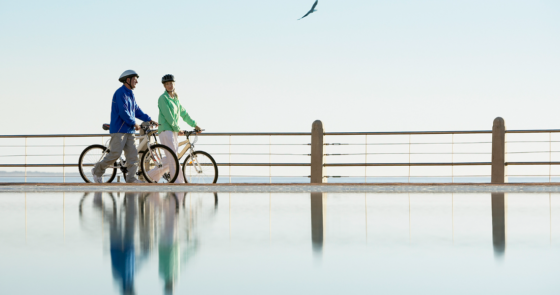Couple riding bikes along the waterfront.