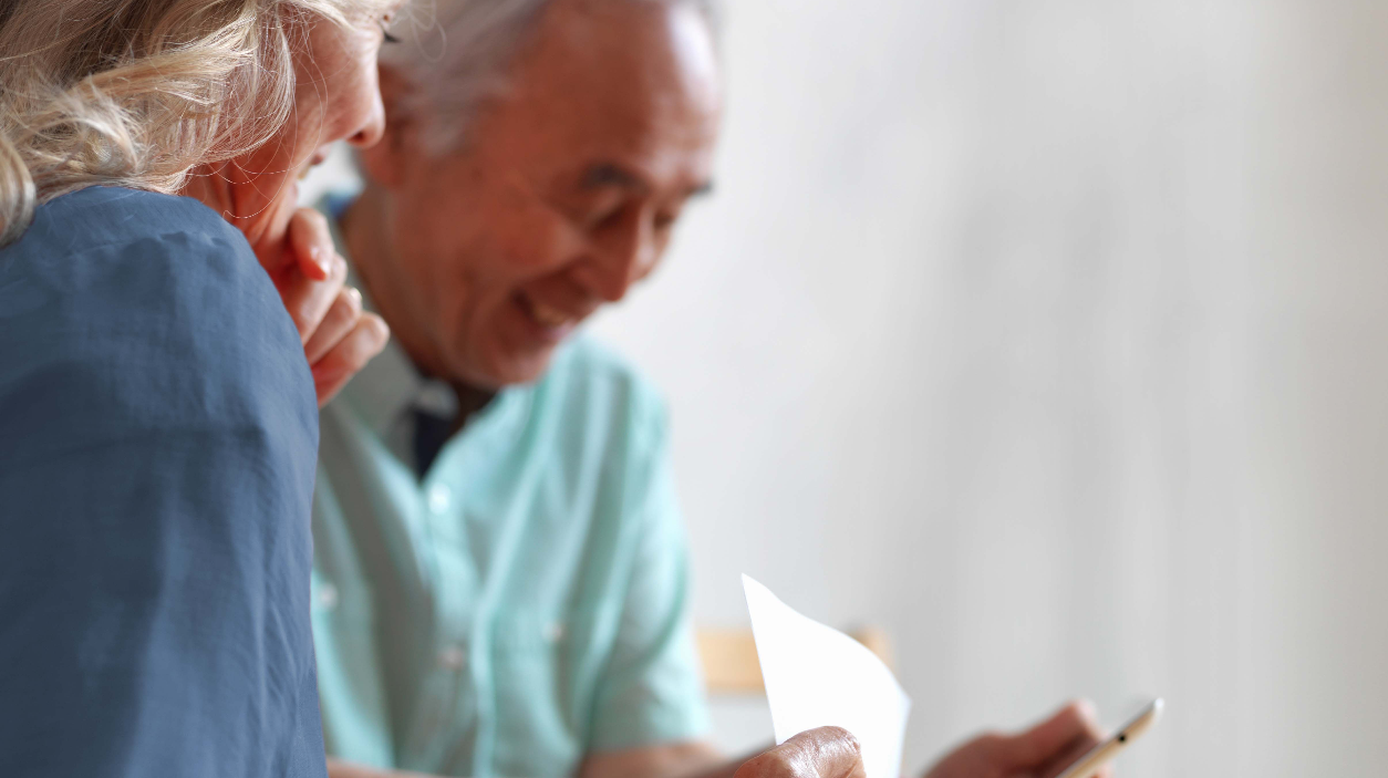 Smiling couple looking at paperwork.