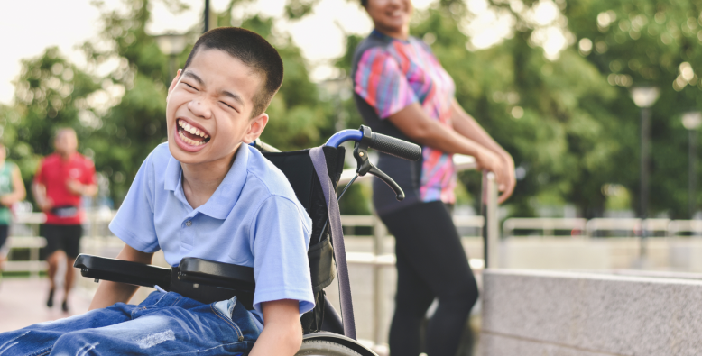 laughing boy in wheelchair in playground