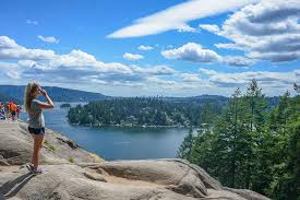 woman at the peak of a hike overlooking the water