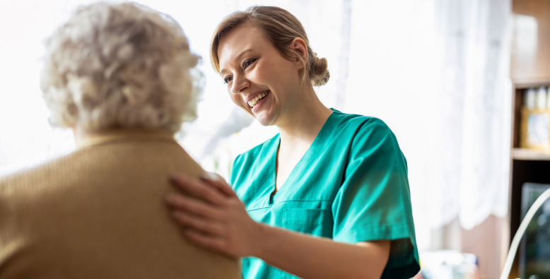 caregiver with hand on eldery woman