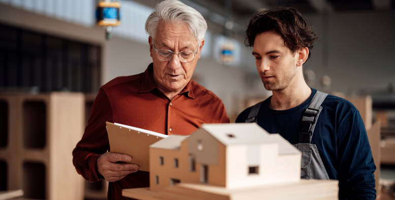 older man and younger man looking at home building plans