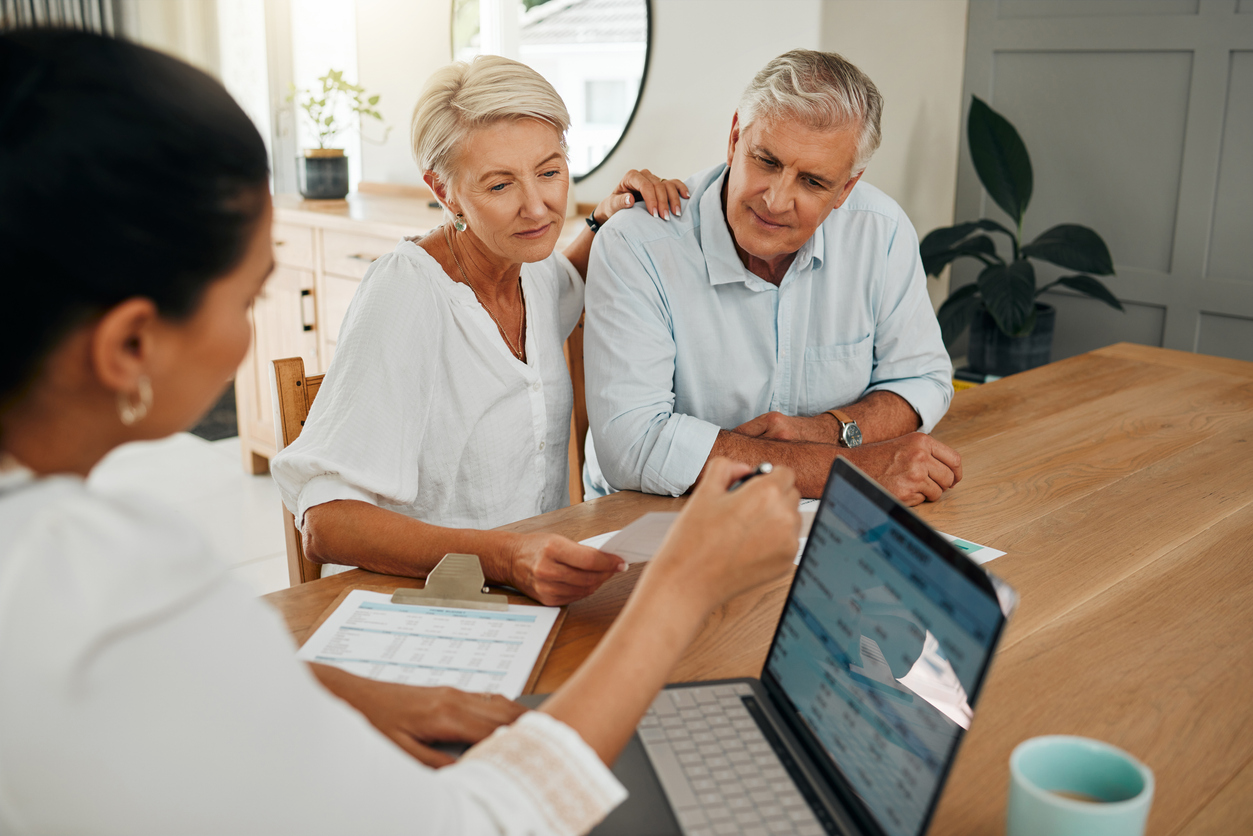 couple working with an investment advisor in their kitchen