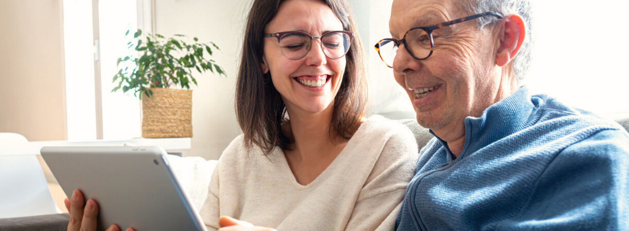 father and daughter reading on an ipad