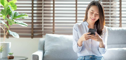 Woman sitting on a couch looking at her mobile device