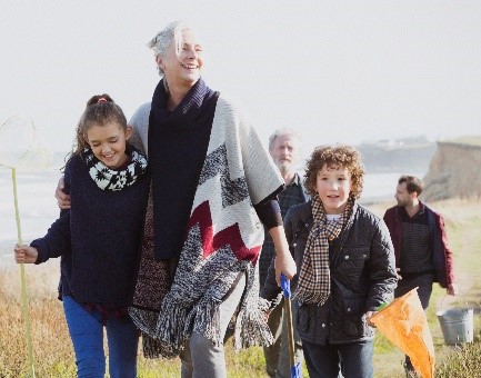 Family walking away from a beach in grassed area