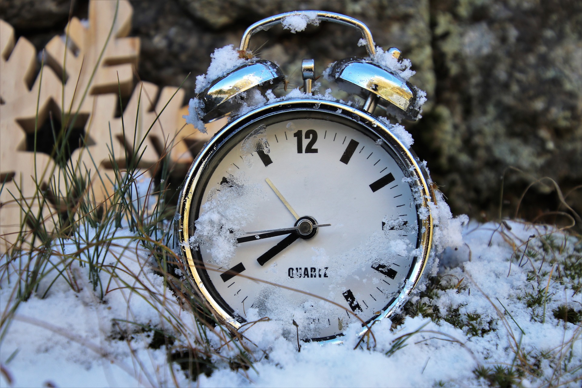 Old fashioned alarm clock in the snow.