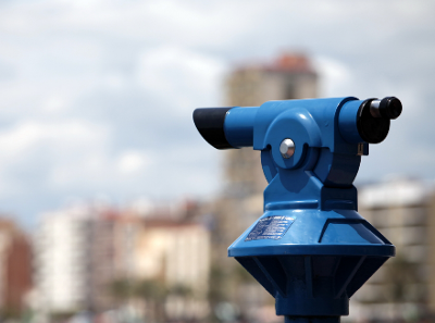A blue tower viewer in front of a blurred city background
