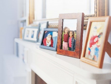 Picture frames on a fireplace mantel. 