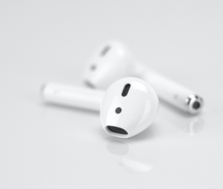White earbuds on a grey background.