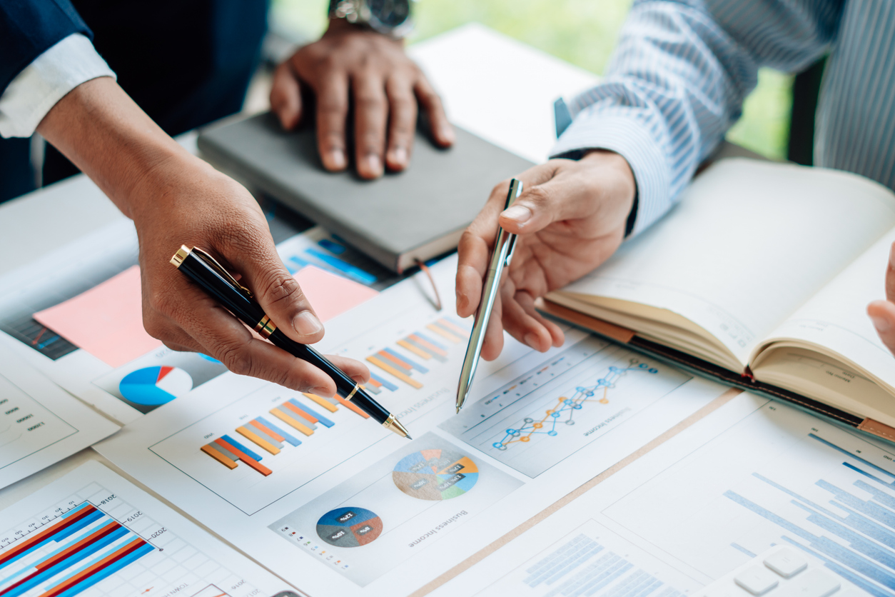 magnifying glass laying on documents with data visualizations