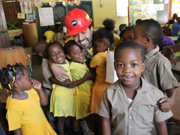 Maymar hugs students in a Jamaican school.