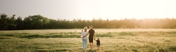Couple with a child walking on a field