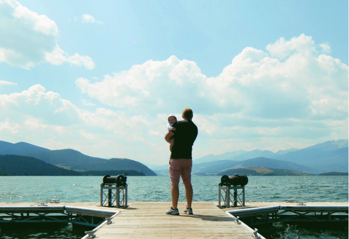 Man holding child on dock