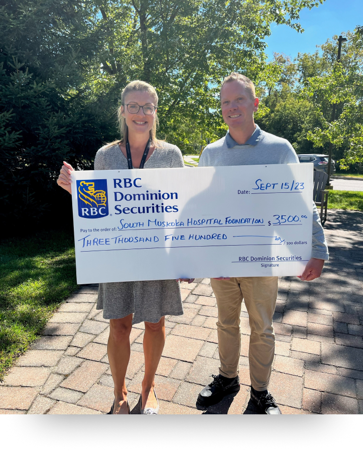 Daryl Knudson and Leah Walker holding large cheque. 