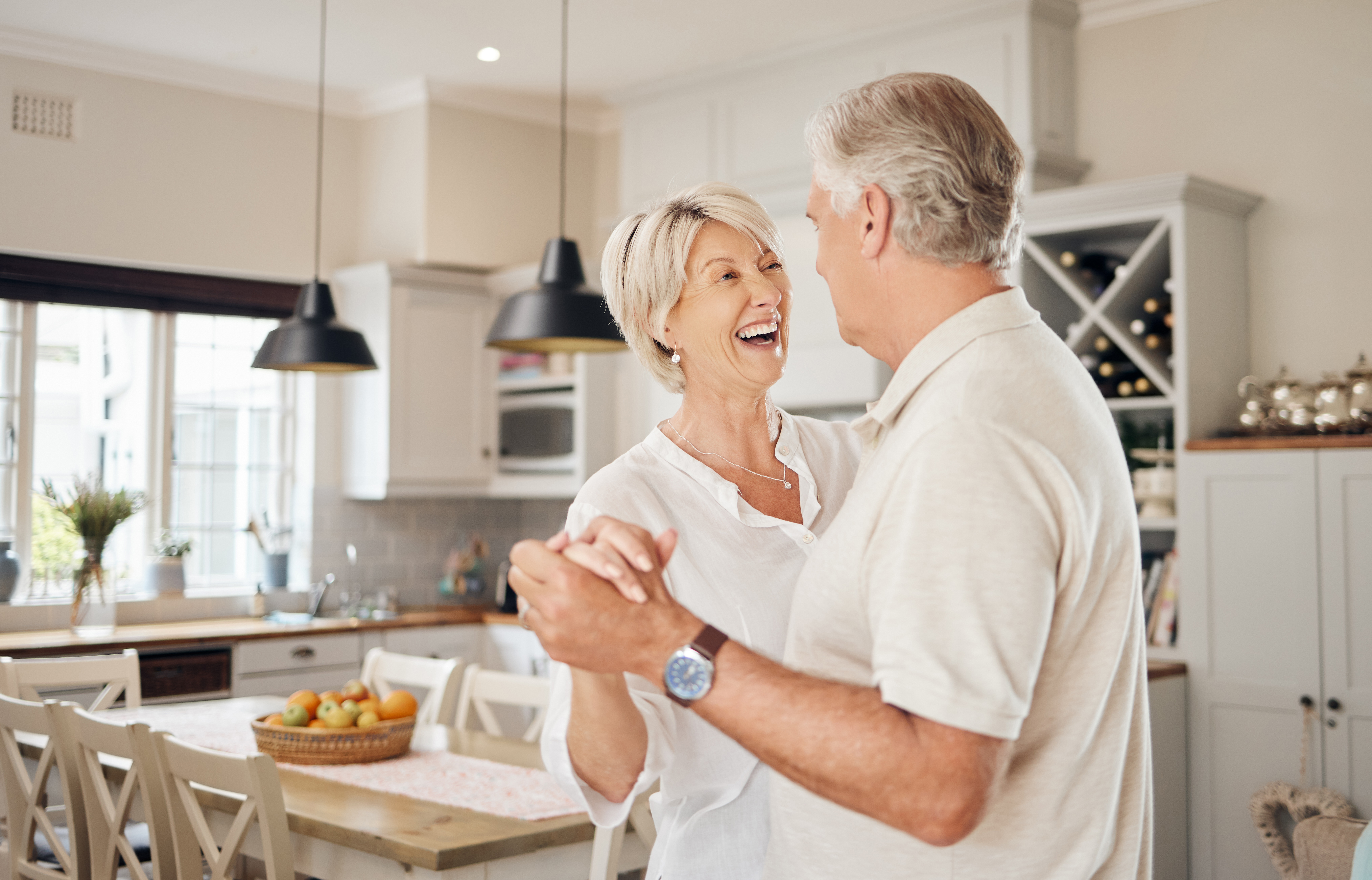 An older couple dancing in a kitchen