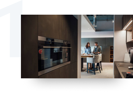 Couple viewing a book at the island of a modern kitchen.