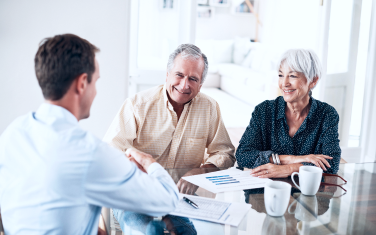 A couple sitting down with an advisor at a table.