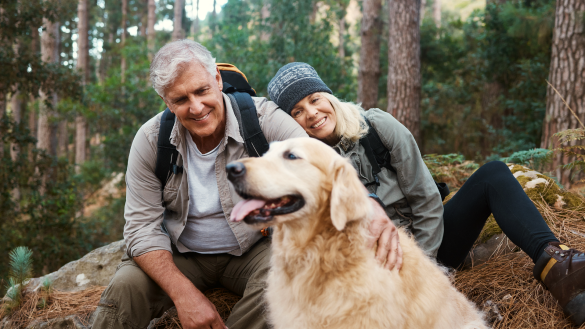 Couple on a hike with their Golden Retriever.