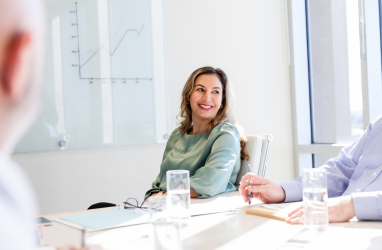 Smiling woman sitting at boardroom table