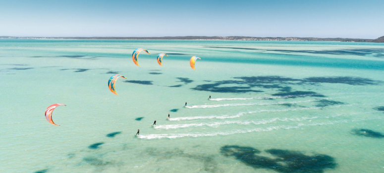 People kitesurfing in crystal clear water