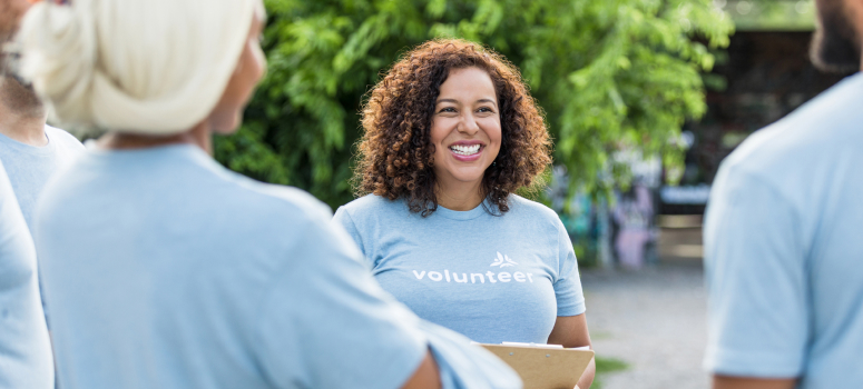 Woman wearing a T-shirt with the word "volunteer" on it, huddled with others wearing the same