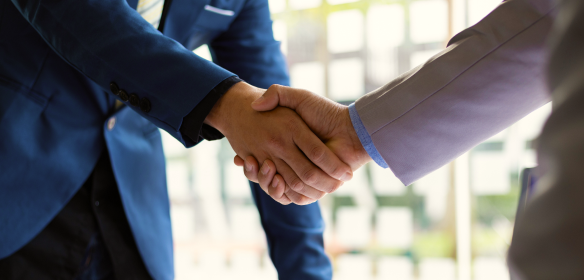 A portfolio manager shaking hands with a client.