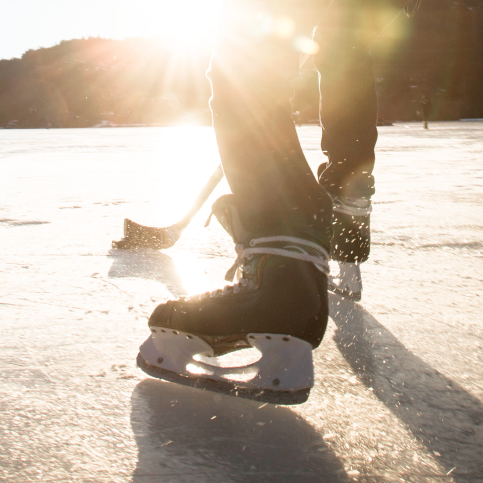 A hockey player playing shinny on a frozen lake.