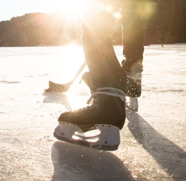 A hockey player playing shinny on a frozen lake.