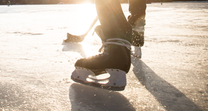 A hockey player playing shinny on a frozen lake.