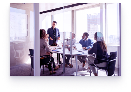 A group of people around a boardroom table in an office.