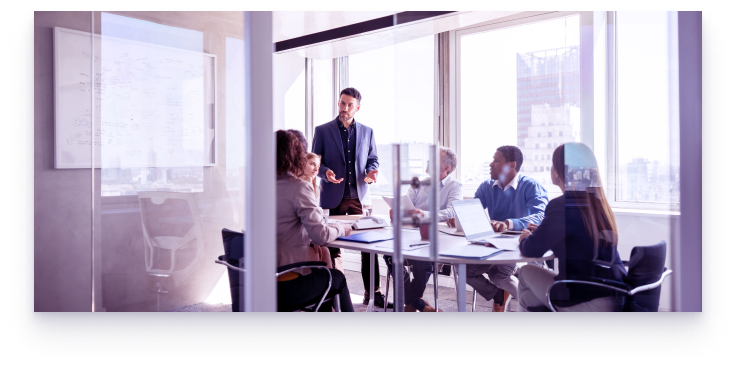 A group of people around a boardroom table in an office.