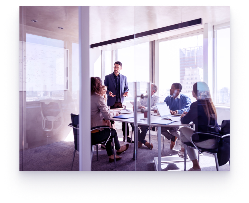 A group of people around a boardroom table in an office.