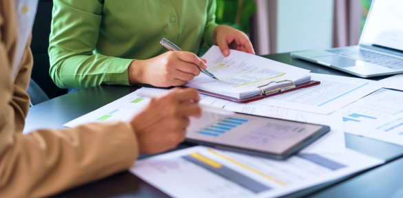 Two people looking at charts in an office.