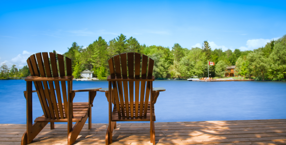 Two muskoka chairs by the water.