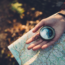 A compass and map in a hand.