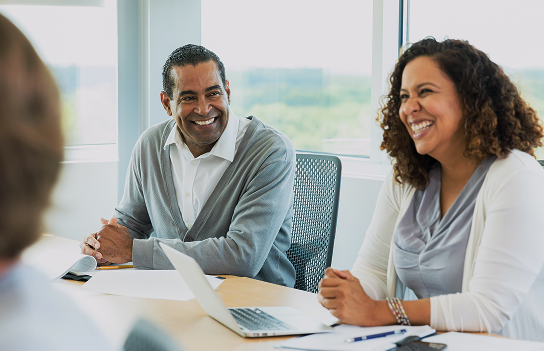 People in a business meeting smiling.