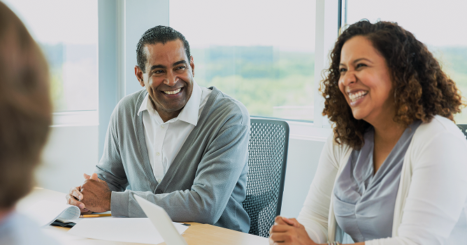 People in a business meeting smiling.
