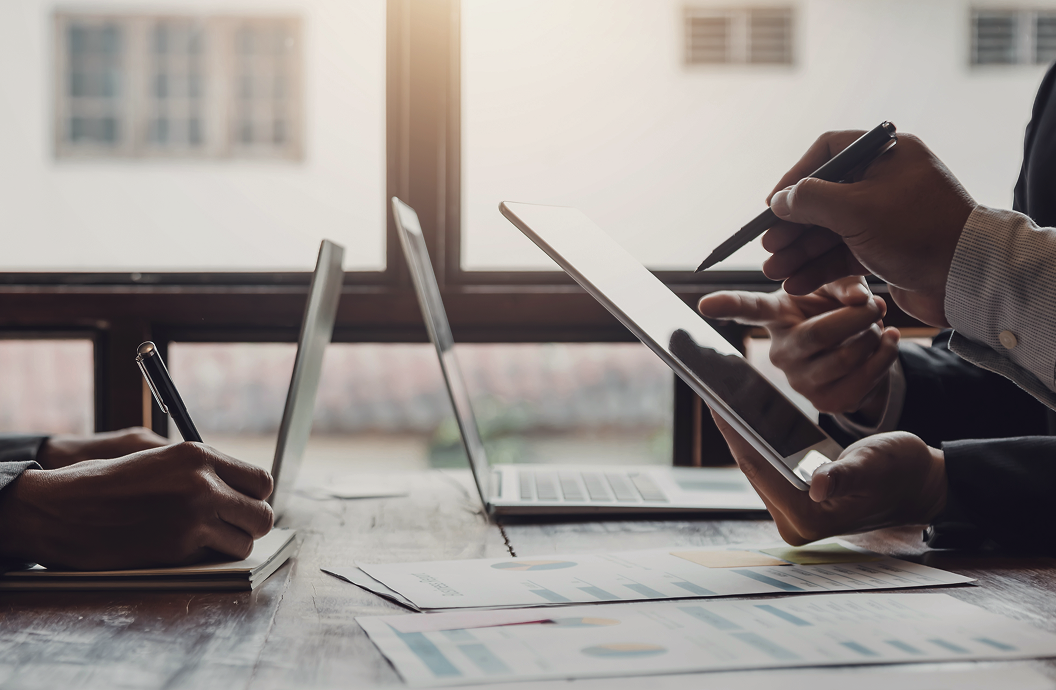 A close up of professionals pointing at an iPad.